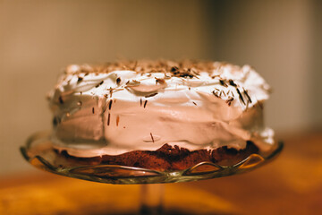 Close up image of a homemade Birthday cake with whipped cream and chocolate crumbs.