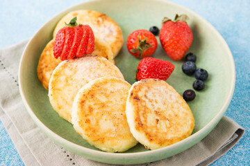 Homemade fried cheesecakes with condensed milk and berries