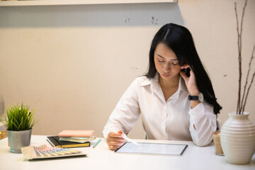 Cropped shot of two UI developers meeting on their project with paperwork and tablet on meeting...