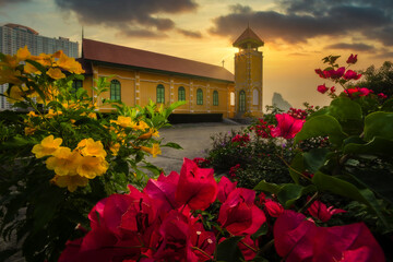A Lone Wooden Church at Dusk with Sunset Clouds and beautiful flowers in the foreground.