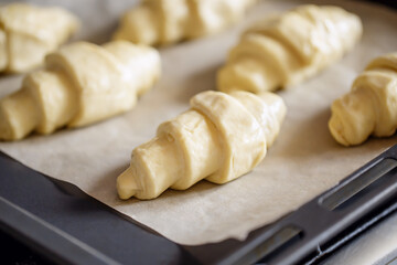 Raw croissant dough on tray - cooking pastry