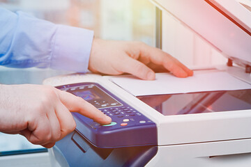 Business man hand press button printer panel to make a copy of the document in the office....