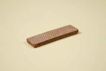 Random pile of wafers isolated on a yellow background. Chocolate biscuit wafers filled with delicious creamy chocolate. Dry and crispy wafers ready to eat. Ready to start the day with a wafer.