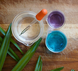 Chemicals for beauty care on wooden background (Top View). Potassium Permanganate Liquid, alcohol, dropper, beaker and Copper(II) sulfate liquid.