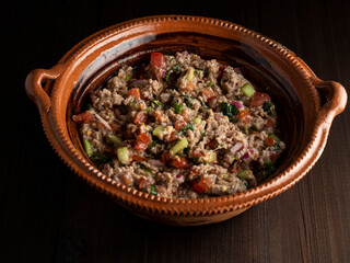 Carne tartara, cocida con limon y mezclada con jitomate, cebolla, cilantro y aguacate, cocina mexicana.