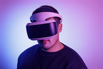 Person looks into virtual reality glasses on an isolated colored background