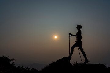 Silhouette Slim Girl of hikers walking in mountains. Woman hiker on a top peak  mountain. Life Balance Woman Exercise. Girl adventure fit trekking and happy