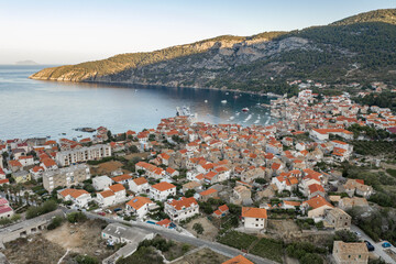 Naklejka na ściany i meble Aerial drone shot of Komiza town on Vis Island in Croatia in sunrise hour