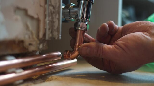 Plumber checking fitment of copper pipe work to newly fitted radiator at home. checking fitment before soldering