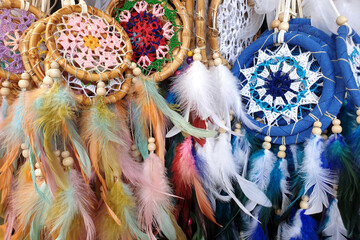 Various designs of dreamcatcher with feather display in a fashion store.
