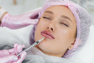 Cosmetology procedure for lip augmentation and wrinkle removal for a young beautiful girl. Cosmetology