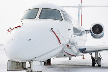 Small white airplane on the airfield in winter time