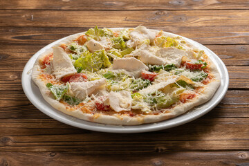 Caesar pizza with chicken breast, lettuce, cherry tomatoes and Parmesan cheese.