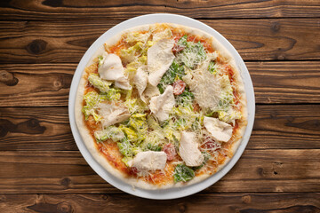 Caesar pizza with chicken breast, lettuce, cherry tomatoes and Parmesan cheese.