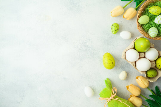 Easter holiday concept with Easter eggs and tulip flowers decor on gray background