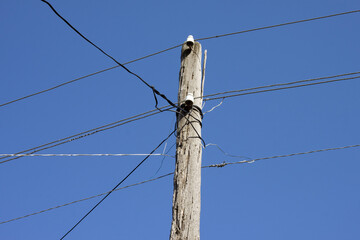 Old Wooden Pole with Electric Wires. A High-Voltage Pole against A Blue Sky. The Concept Of Electricity, Outdated Technologies, Current