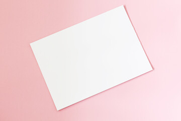 Obraz na płótnie Canvas blank paper sheet on pastel pink background
