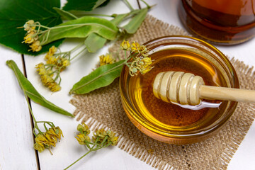 Linden honey in glass bowl and linden flowers
