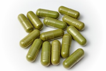 Integratore alimentare. Capsule di moringa oleifera disposte su fondale chiaro.