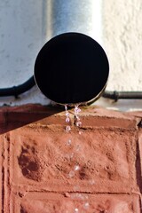 drain downpipe on wall of house with blurred motion of falling drops close up