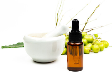 Neem oil in bottle and neem fruit with white ceramic mortar and pestle isolated on white background.