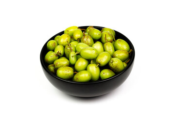 Fresh Neem fruit in black ceramic bowl isolated on white background. Neem fruit is an excellent moisturizing and contains various compounds that have insecticidal and medicinal properties.