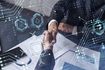 Handshake of two businesswomen who enters into the contract to develop a new software to improve business service at a company. Technological icons over the table with the document.