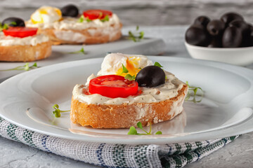 Bruschetta with tomato, olives and poached quail egg