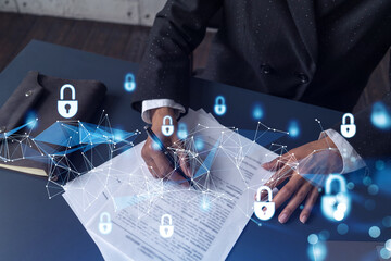 African American businesswoman in formal wear signing the contract to prevent probability of risks in cyber security. Padlock Hologram icons over the working desk. Women in business concept.