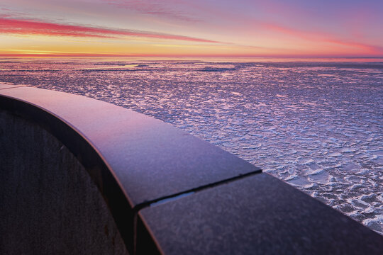 Ice sculpture mooring post during sunset in winter at the Afsluitdijk in The Netherlands