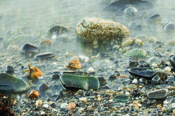 Low tide cold water washes over stones on the Maine Coast