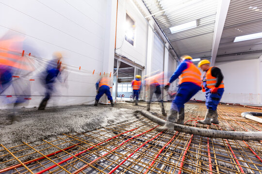 Workers Do Concrete Screed On Floor With Heating In A New Warehouse Building