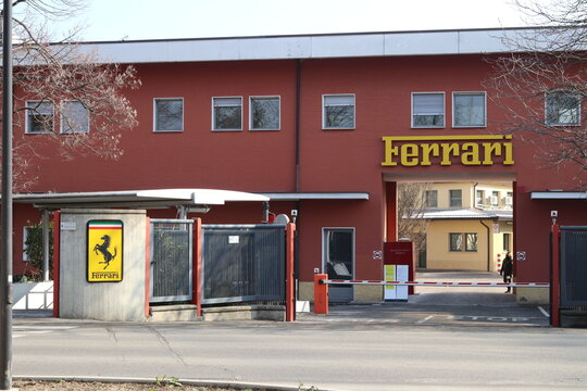 Maranello, Modena, Italy, February 2021 - Entrance of the original Ferrari Automobiles factory with the Ferrari logo in the foreground