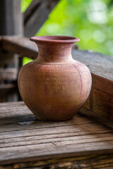 Old clay vase of manual work on wooden table in thai home