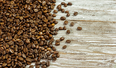 Grains of coffee on a wooden background.