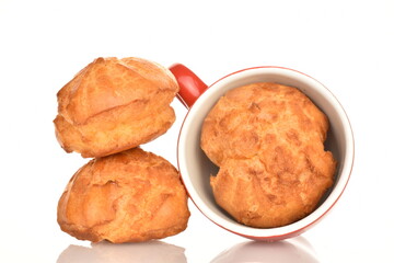 A few sweet chouquettes with a coffee cup, on a white background.