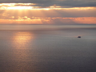 Sunset over the Sea of the Hebrides with ferry plying across the sea towards the Sound of Mull 