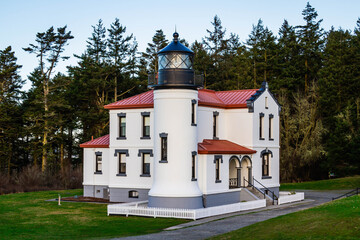 The admiralty Head Lighthouse with classic Pacific Northwest woods behind it on Whidbey Island.