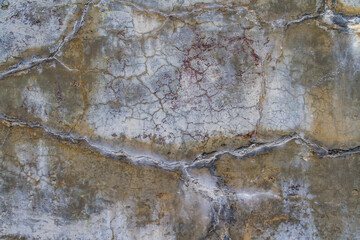 Concrete wall that is heavily cracked with age textured background.