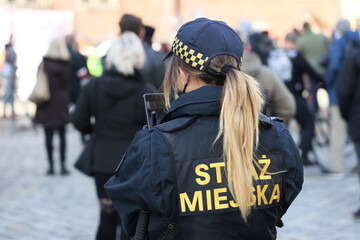 Straż miejska Wrocławia w czasie patrolu w mieście z kamerą.  - obrazy, fototapety, plakaty