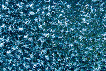 Obraz premium Transparent Ice Floe with cracked crystals with bubbles texture background against light. Cold winter ice texture. close up, macro abstract pattern detail