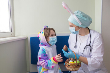 Easter in the hospital: the doctor nurse gives the girl a chocolate egg