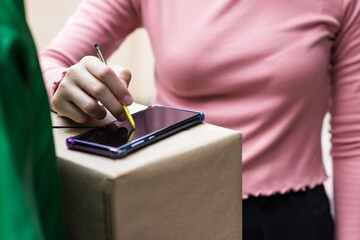 Woman sign signature to receive package by deliveryman