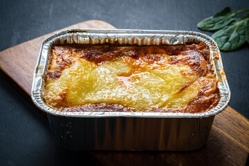 Lasagna on black wooden table
