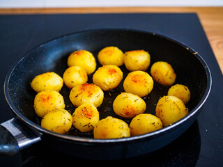 Frying small potatoes in pan
