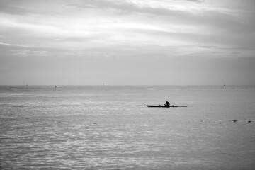 Man paddling a Hawaiian canoe during a late afternoon.
