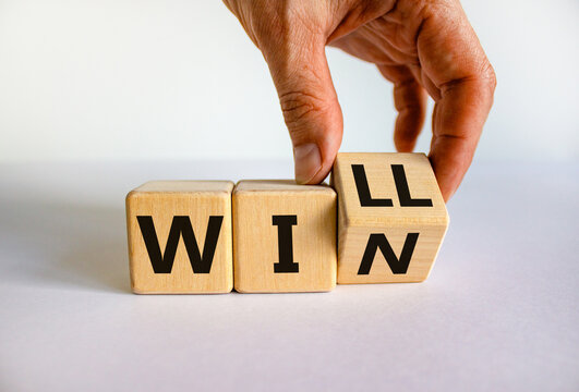 We will win symbol. Businessman turns cubes and changes the word will to win. Beautiful white background, copy space. Business, motivational and we will win concept.