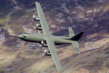 C-130 Hercules flying low level in the UK. Four engines turboprop transport and cargo plane low level in a valley
