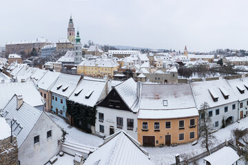 Obraz premium Panoramic view of Cesky Krumlov in winter season, Czech Republic. View of the snow-covered roofs. Travel and Holiday in Europe. Christmas time. Historical houses and streets. UNESCO World Heritage