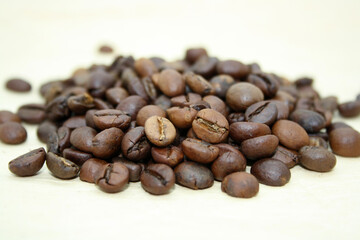 Grains of fragrant fresh coffee on craft paper.